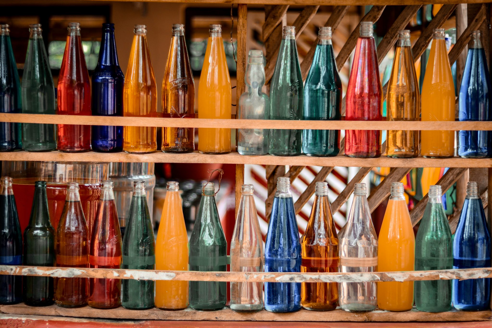 Rows of bottled drinks on a storefront shelf