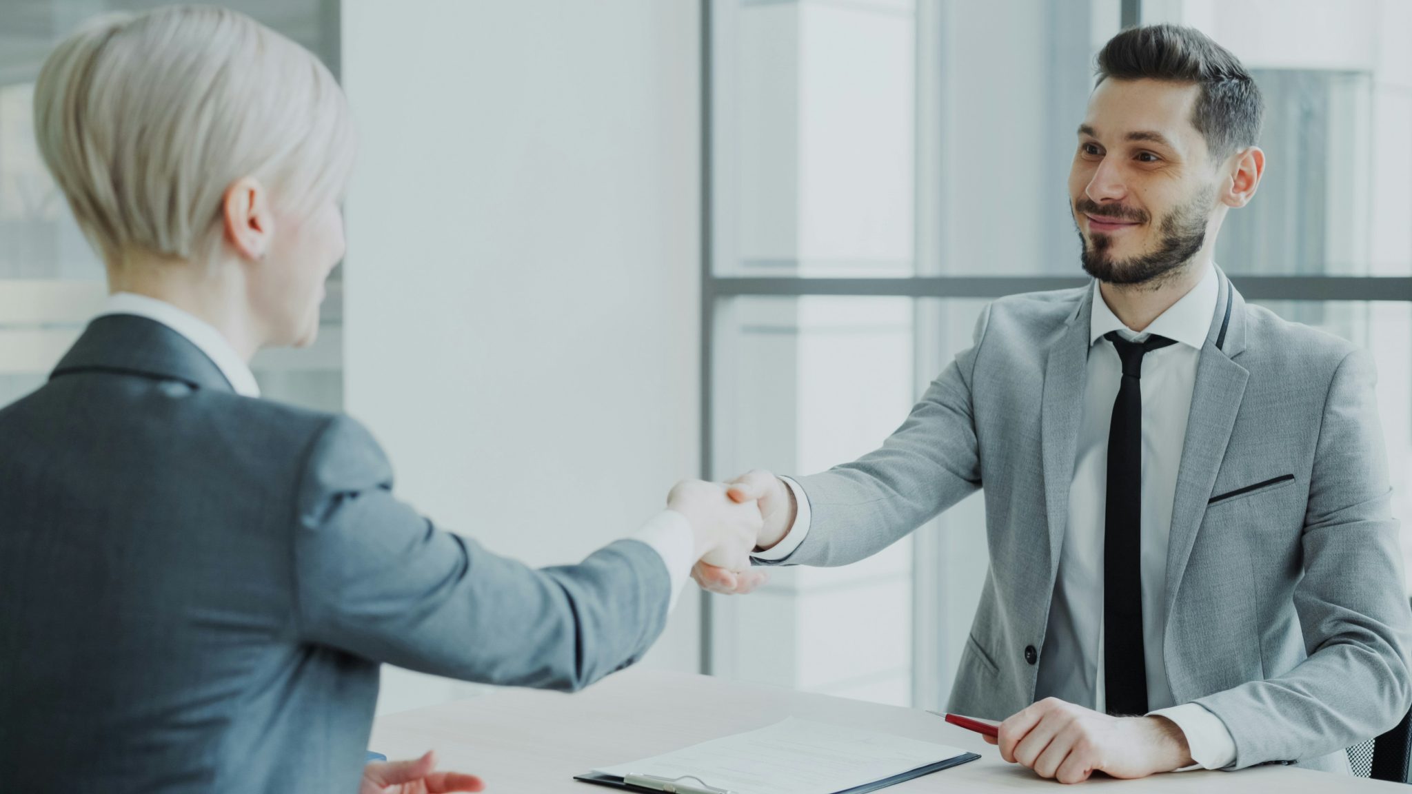 Two business professionals agreeing food supply terms across a table
