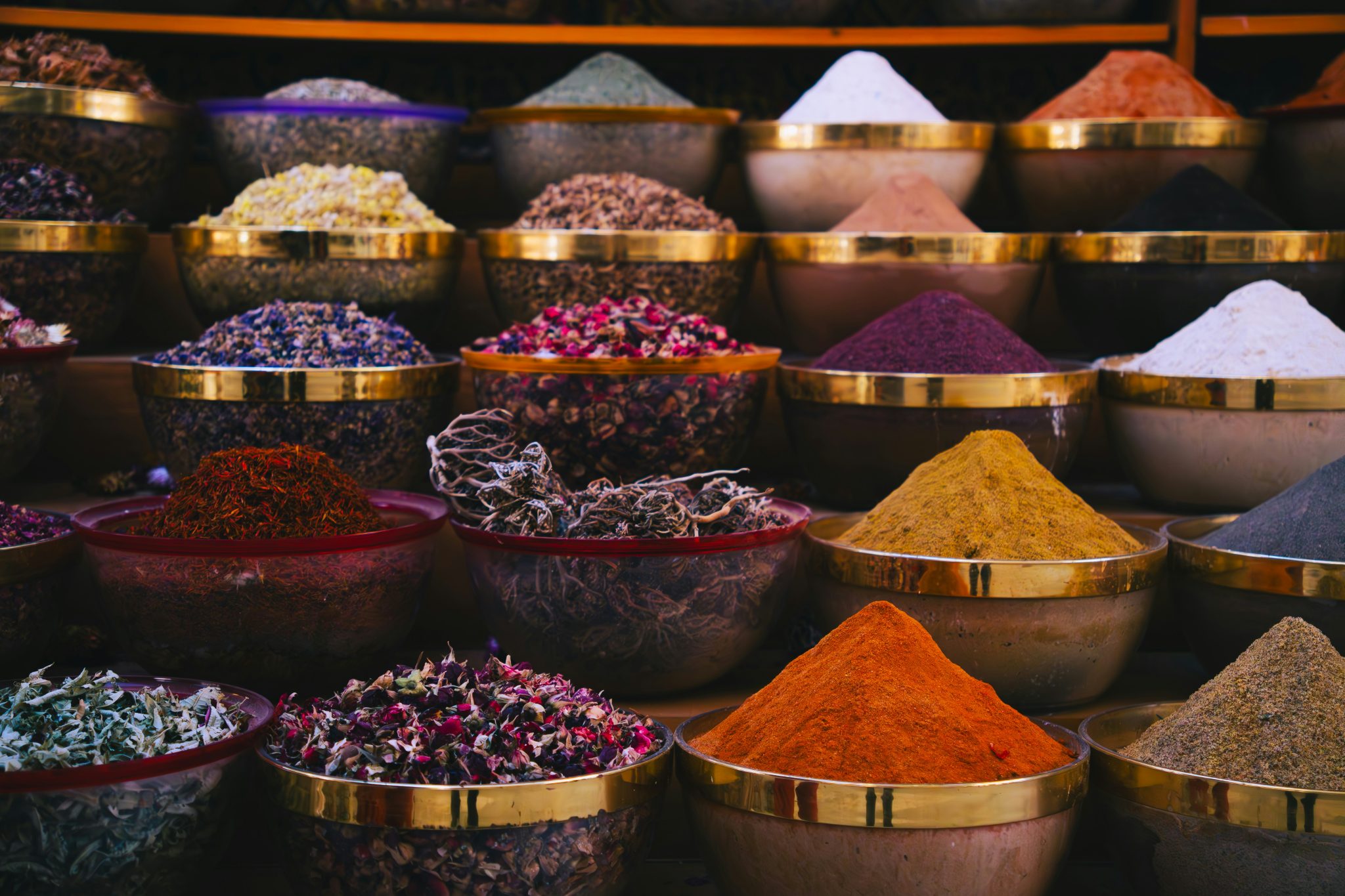 Rows of whole and ground spices displayed in bowls for wholesale food supply